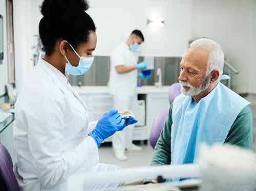 Dentist discussing model teeth with patient