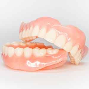 Full set of dentures on a white surface