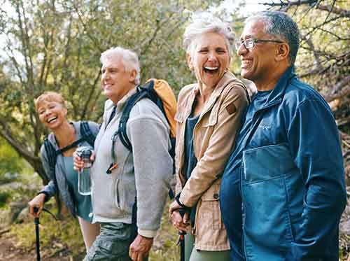 Four adults walking outside on a nature trail