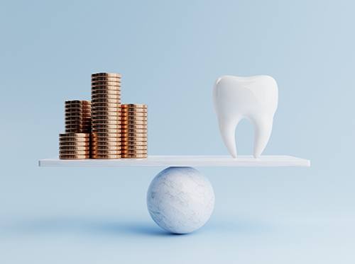 Stacks of gold coins and a model tooth on a balance beam