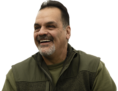 a smiling man wearing a green jacket