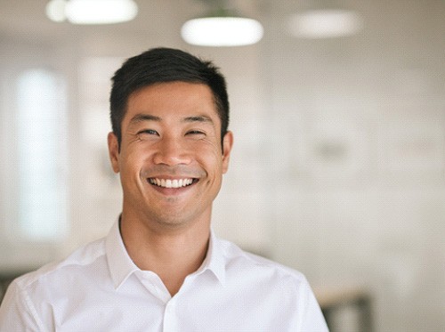 Man in white collared shirt smiling in office