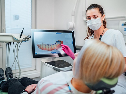 a dentist showing a patient a digital rendering of their teeth