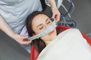 Female dental patient having nasal mask placed for nitrous oxide sedation