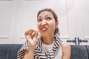 Woman making goofy expression as she uses a toothpick 