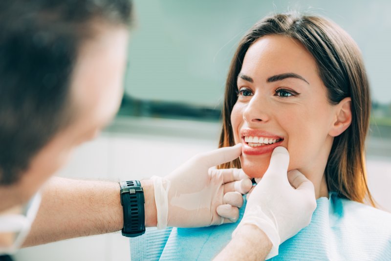 A dentist assessing a patient’s smile for cosmetic dentistry